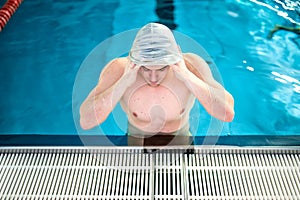 Male athlete, polo player getting ready for swimming. Swimmer wearing rubber cap