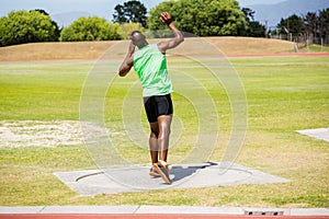 Male athlete preparing to throw shot put ball