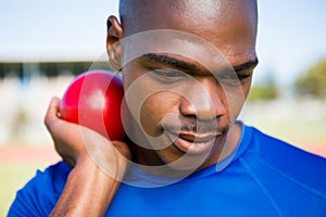 Male athlete preparing to throw shot put ball