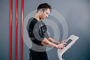 Athlete regulating intensity of ems electro muscular stimulation machine