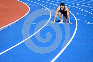 Male  athlete on  race track is ready to run