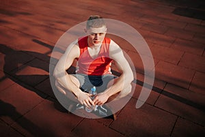 Male Athlete Recovering and Rehydrating with Water Bottle