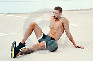 Male athlete, rest and body with medicine ball for sports, exercise and fitness on break. Healthy, man and topless in