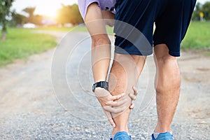 Male athlete runner muscle and ankle injury after jogging. Athlete man runner touching muscle in painful. Muscle and ankle injury