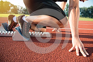 Male athlete on starting position at athletics running track.