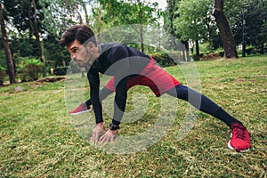 Male athlete stretching muscles at the park. Healthy, fitness, wellness lifestyle. Sport, cardio, workout