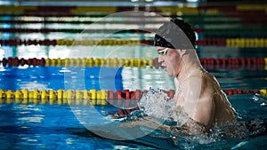 Male athlete swimming in breaststroke style in the pool