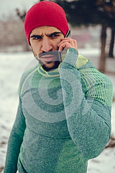 Male athlete talking on the mobile phone outdoor