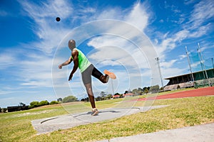 Male athlete throwing shot put ball
