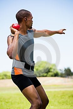 Male athlete about to throw shot put ball