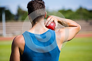 Male athlete about to throw shot put ball