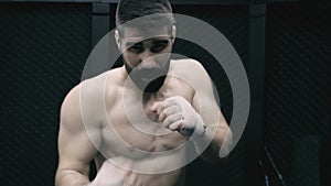 Male athlete training boxing moves in empty factory. Shadow boxing