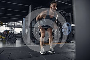 The male athlete training hard in the gym. Fitness and healthy life concept.