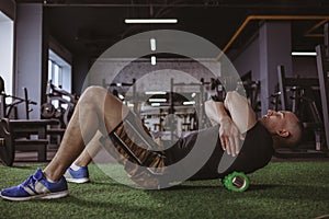 Male athlete using foam roller at the gym