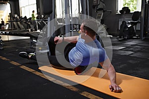 Male athlete using foam roller at the gym