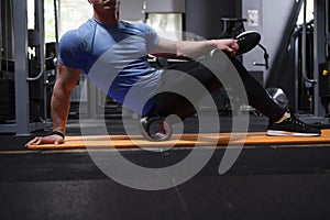 Male athlete using foam roller at the gym