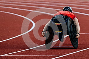 male athlete in wheelchair racing red track stadium in para athletics