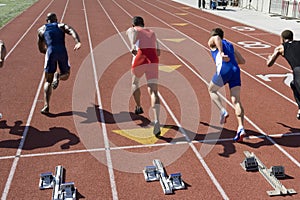 Male Athletes Running From Starting Block