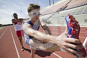 Male Athletes Stretching On Racetrack