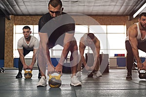 Male Athletes Training With Kettlebells in Crossfit Gym.