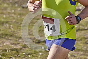 Male athletic runner on a cross country race. Outdoor circuit