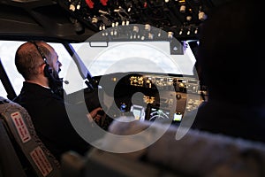 Male aviators flying airplane from cockpit with control panel