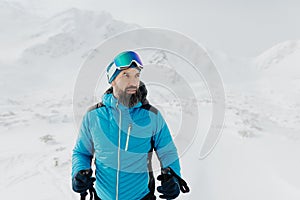 Male backcountry skier hiking to the summit of a snowy peak in the Low Tatras in Slovakia.