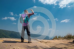 Male Backpacker Stand on cliff while Travel Trekking Trip over G