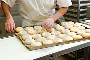 Male baker baking bread rolls