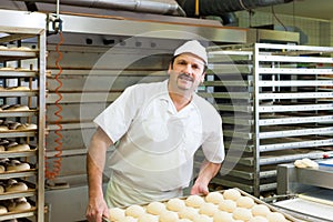 Male baker baking bread rolls