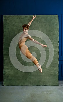 Male ballet dancer jumps in dancing studio