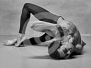 The male ballet dancer posing over gray background