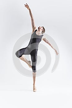 Male Ballet Dancer Young Caucasian Athletic Man in Black Suit Posing Flying Dancing in Studio On White With Lifted Hands