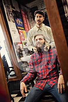 Male barber checking symmetry beard