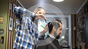 Male barber and client are talking about haircut, smiling and laught