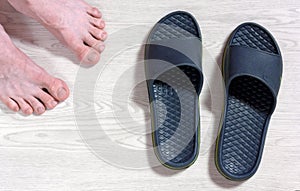 Male Bare Feet and a Pair of Flip Flops