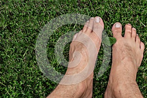 Male bare feet walk on green grass. Summer walk barefoot on the lawn. 3D illustration