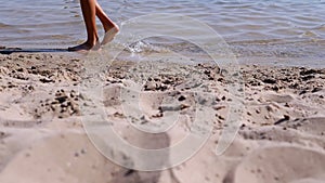 Male Bare Feet Walking by the Waves along the Seashore on Sandy Beach on Sunset