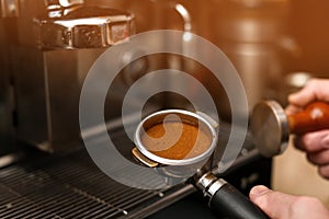 Male barista making espresso using professional coffee machine