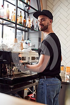 Male barista working on coffee machine photo