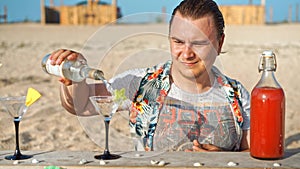 Male bartender mixes custom cocktail for beachgoer