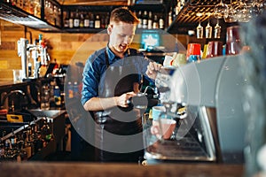 Male bartender prepares drink at the bar counter