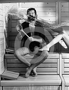 Male bather holds spoon in sauna, thermal bath on wooden background. Male bather holds spoon in sauna, thermal bath on