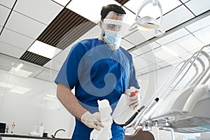 Male bearded dentist carefully sterilize the medical equipment photo