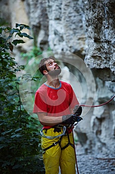 Male belayer with the rope under the cliff