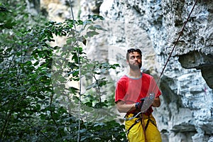 Male belayer with the rope under the cliff