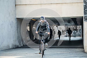 Male bicycle courier delivering packages in city. Copy space.