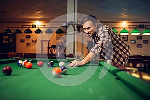 Male billiard player with cue at the table