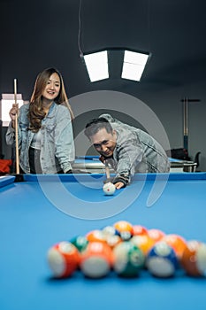 male billiard player poking the cue ball seriously