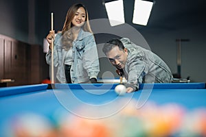 male billiard player poking the white ball for starting the game